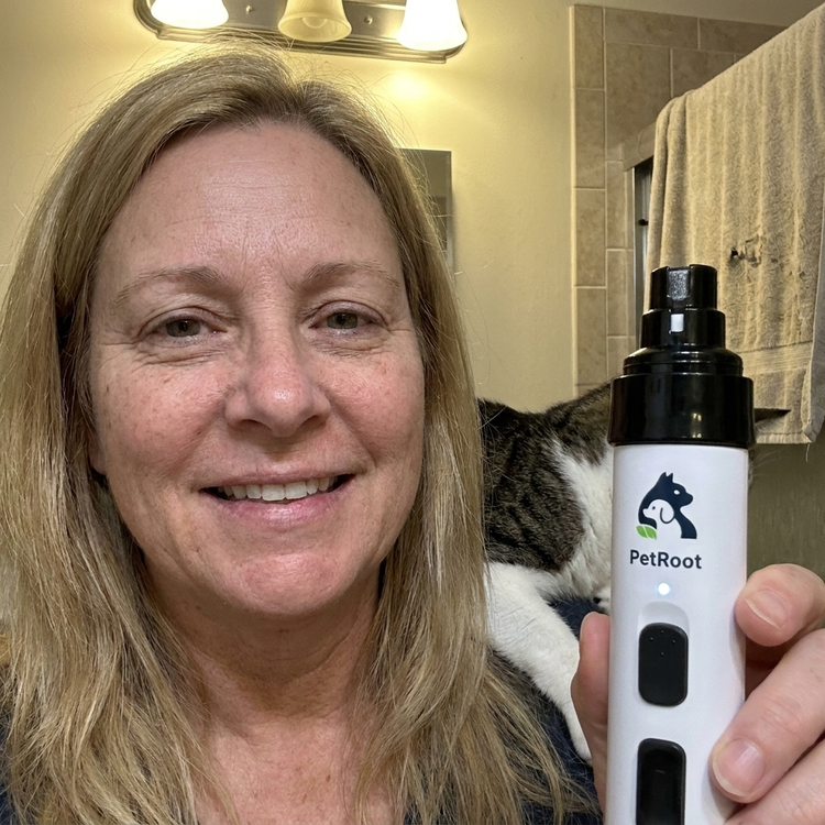 PetRoot Silent Nail Trimmer — customer photo of an owner holding up the trimmer with her cat behind her