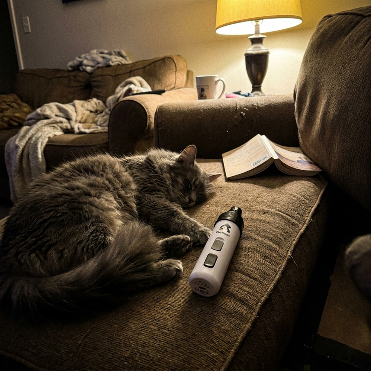 PetRoot Silent Nail Trimmer — customer photo of a long-haired cat asleep beside the trimmer